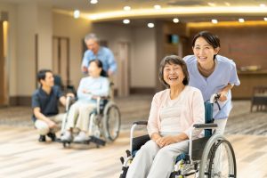 介護施設内で車椅子を使用する入居者と職員によるレクリエーション・生活風景